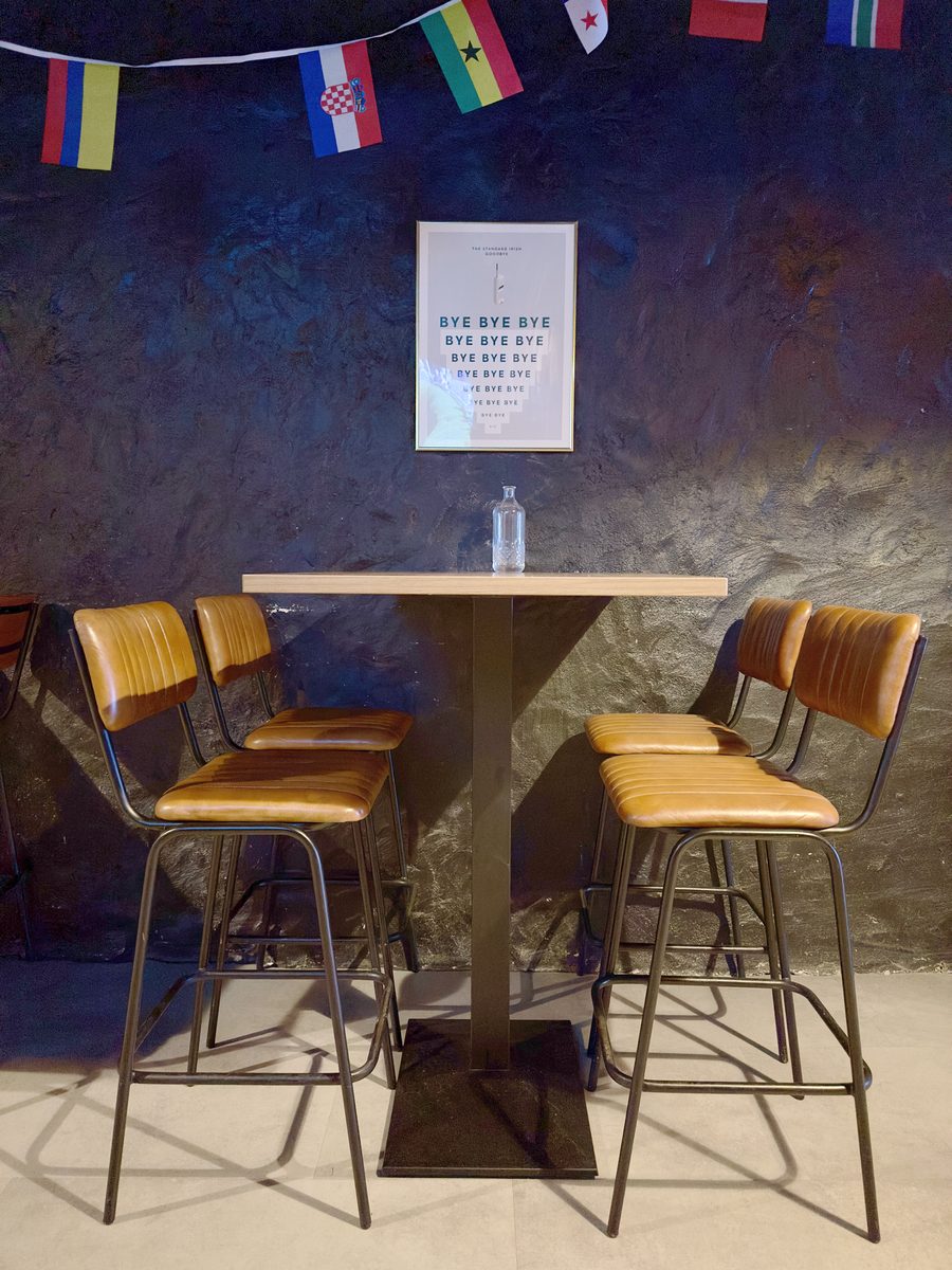 Bar table and stools against the stone wall
